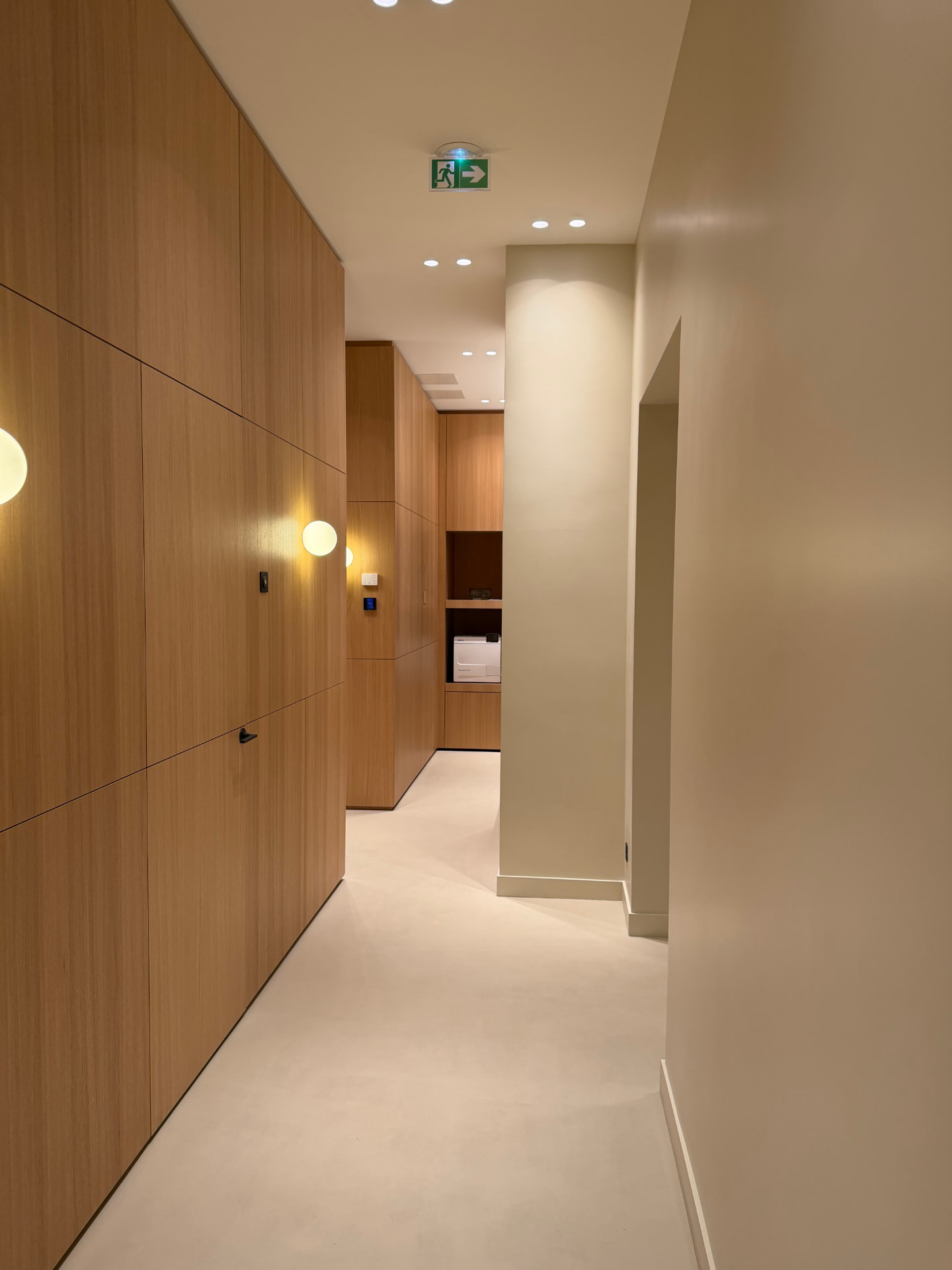 Couloir du cabinet, boiseries claires et éclairage doux