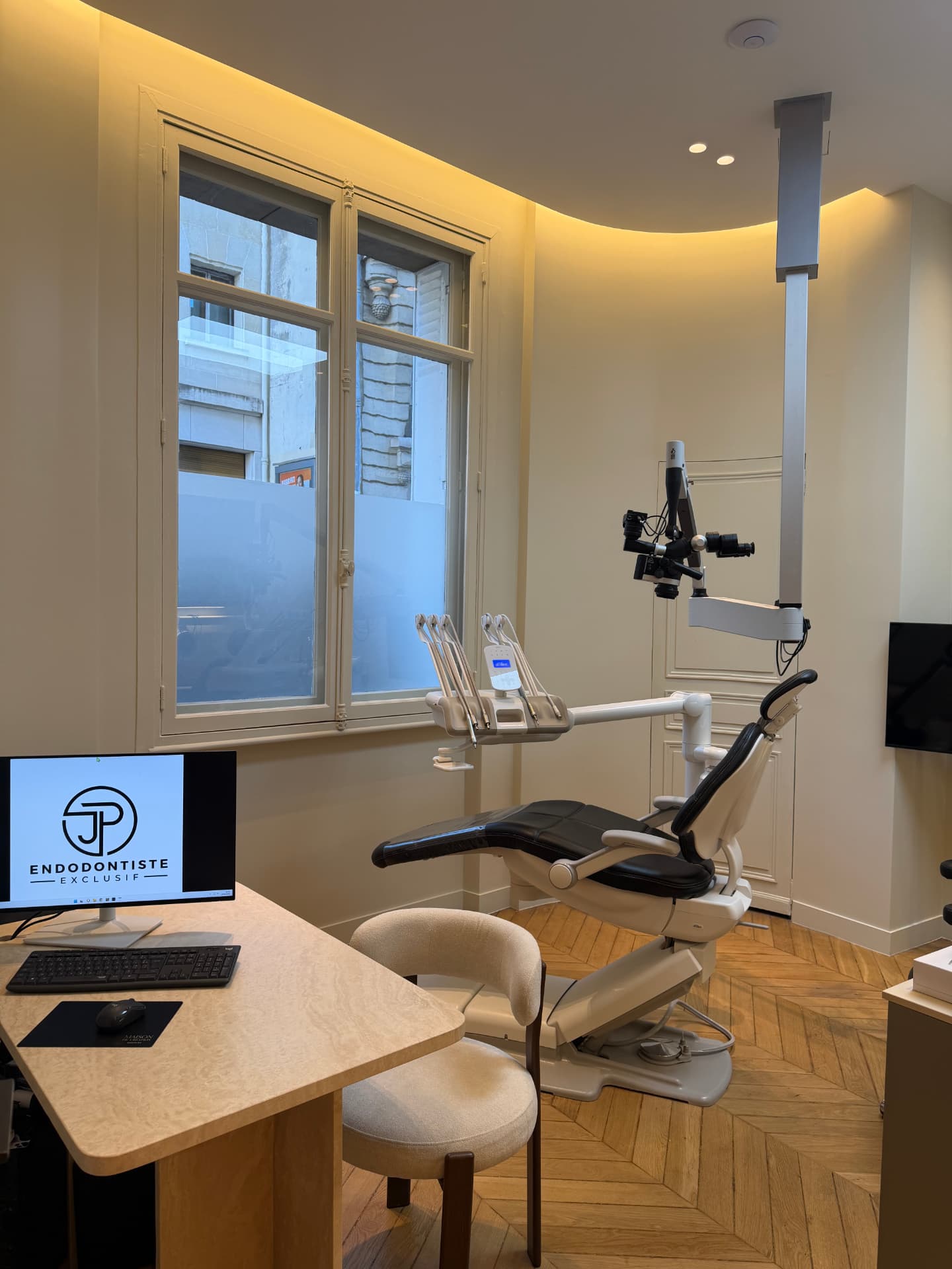 Salle de soins du cabinet : fauteuil, microscope opératoire et bureau